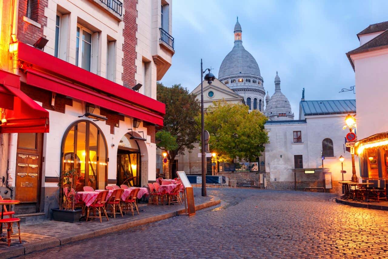 A Place du Tertre com as mesas dos cafés e a Basílica do Sagrado Coração pela manhã, no bairro de Montmartre, em Paris, França