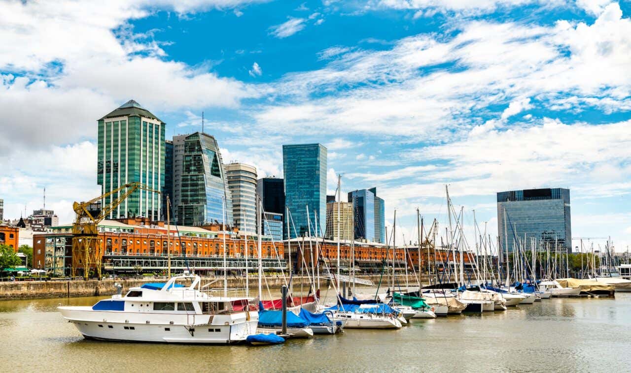Barcos parados na marina de Puerto Madero com edifícios modernos ao fundo