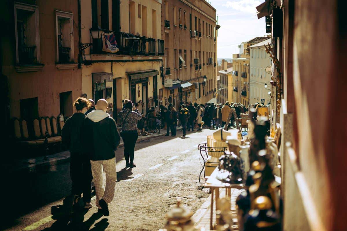 People walking down a street in El Rastro, in La Latina, Madrid.