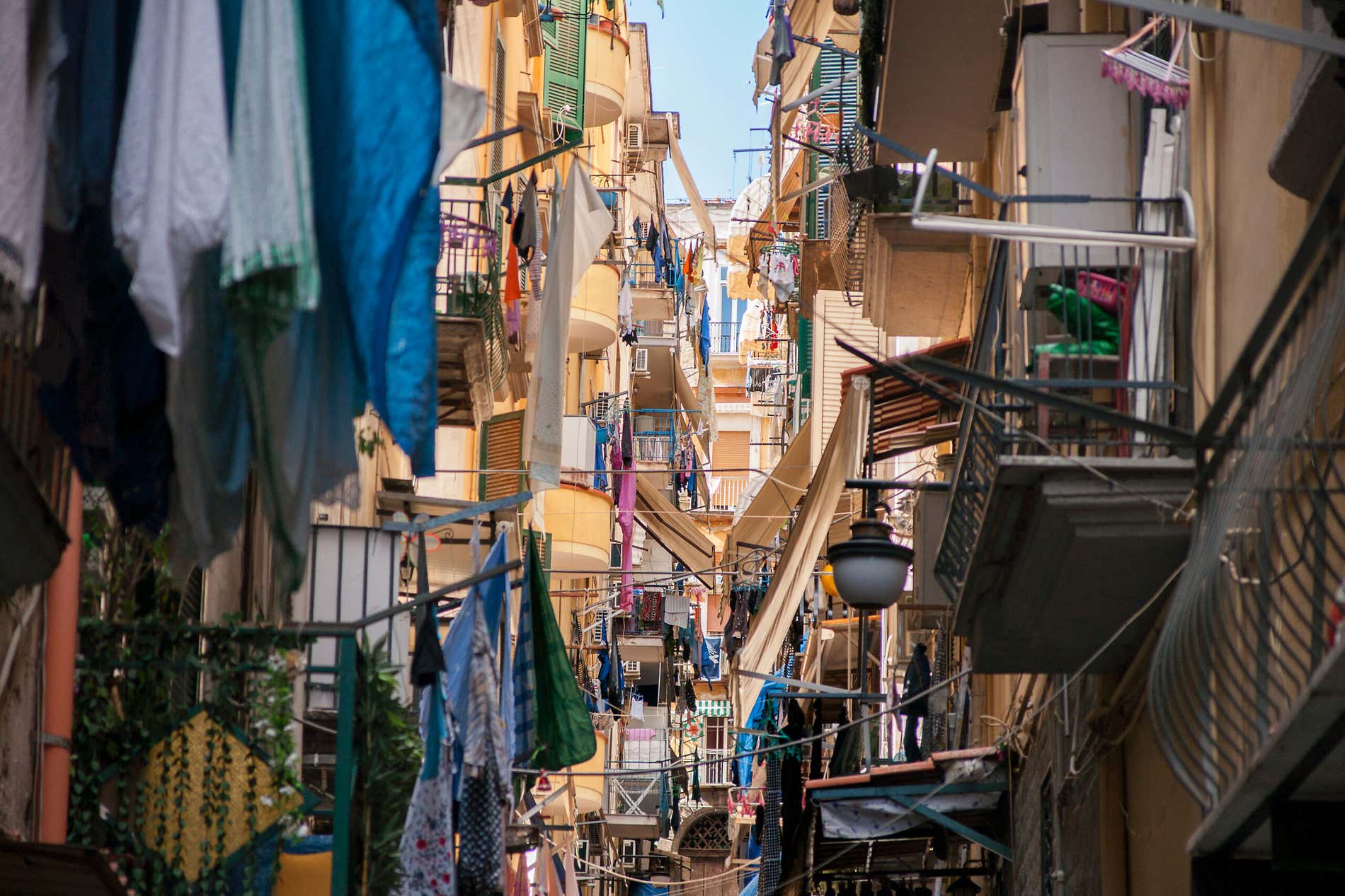 Una vicolo di Napoli in salita con panni appesi sui balconi e fra gli edifici