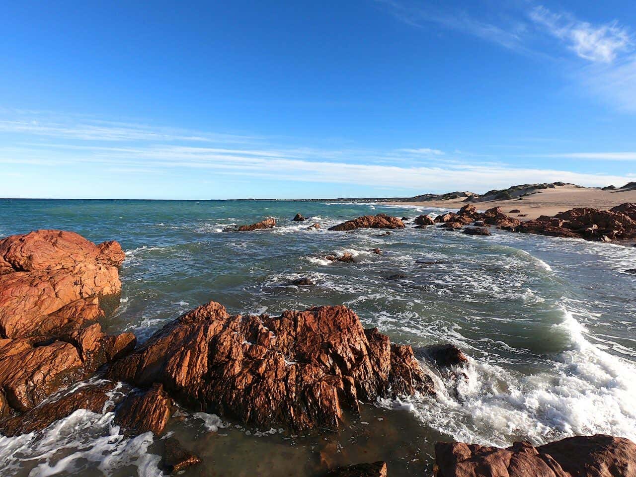 Panoramica di una spiaggia rocciosa al tramonto