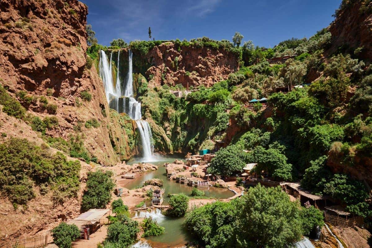 Views of the Ouzoud Waterfalls with vegetation on a sunny day.