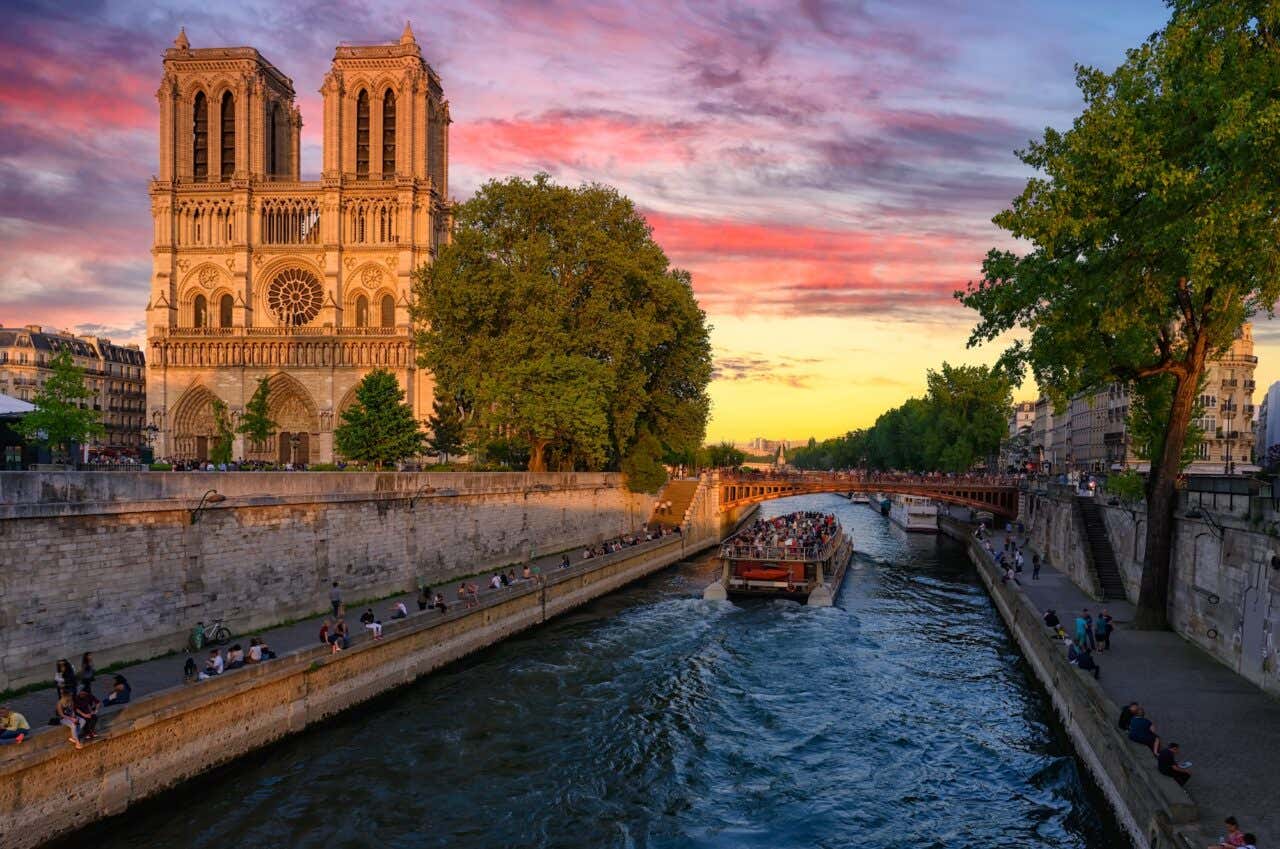 Vista do pôr do sol sobre a Catedral de Notre-Dame de Paris, a Ilha da Cité e o rio Sena, em Paris