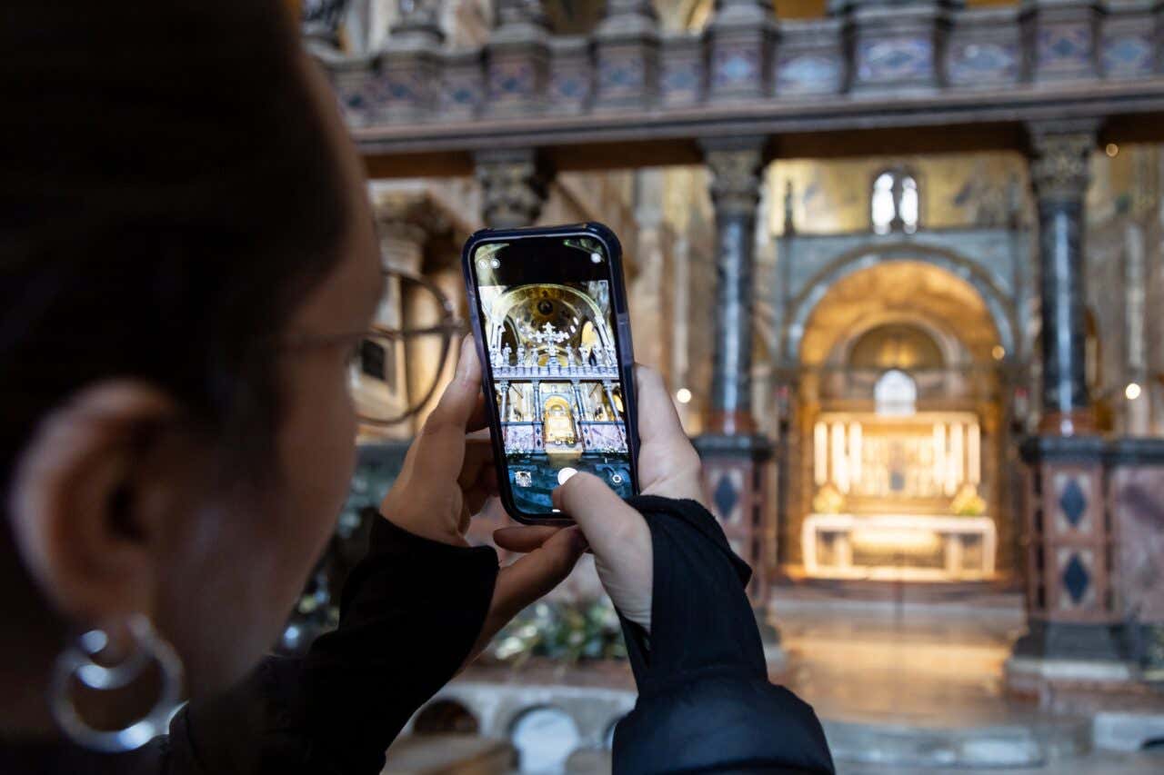 Una turista scatta una foto all'interno di una chiesa