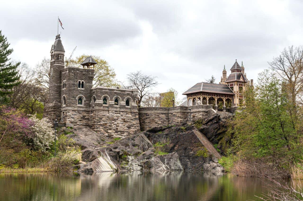 Panorâmica do Belvedere Castle sobre um lago rodeado de vegetação outonal