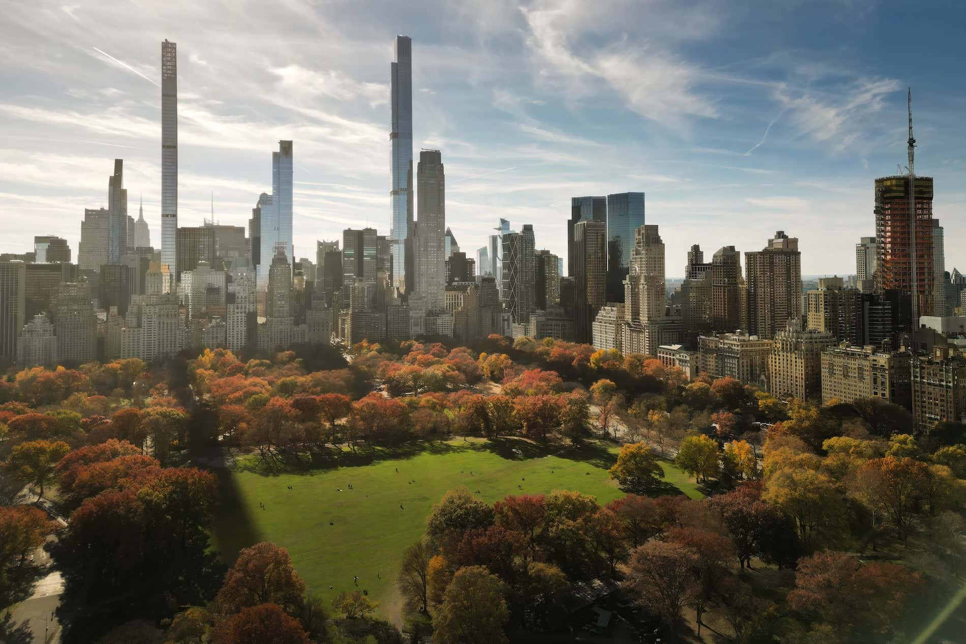 O Central Park durante o outono na cidade de Nova York. Outono com arranha-céus e laranjeiras.