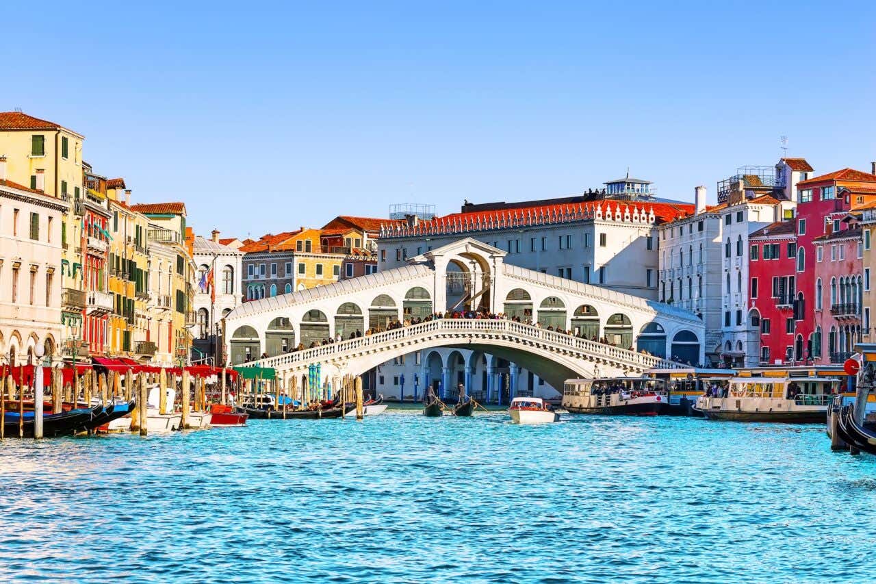 Vista do Grande Canal com a Ponte de Rialto e gondoleiros em Veneza