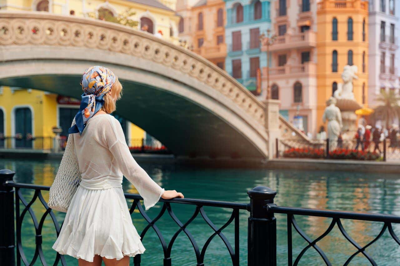 Una ragazza di spalle con una bandana osserva un canale di Venezia