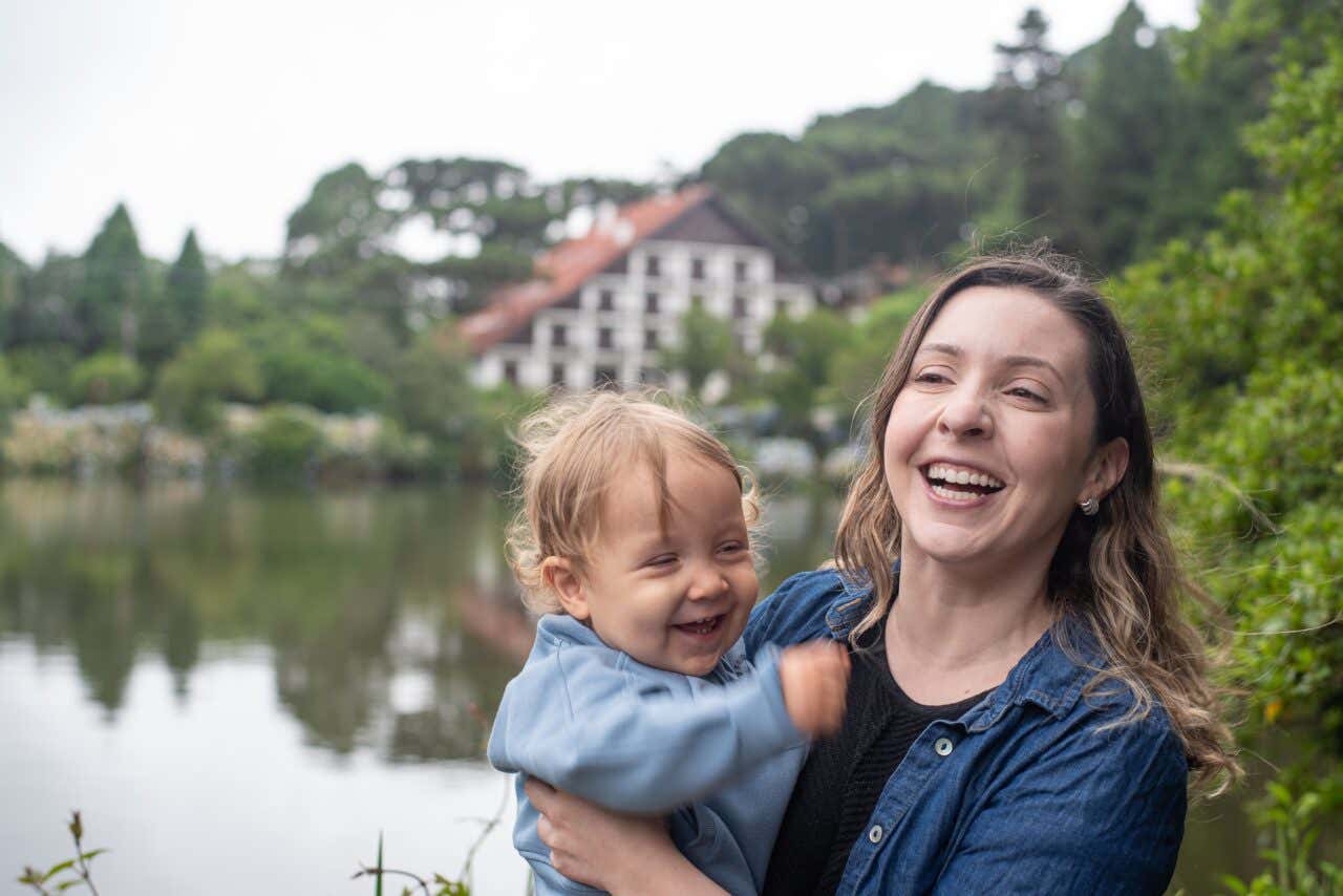 Uma mãe segurando seu bebê com o Lago Negro em Gramado na Páscoa