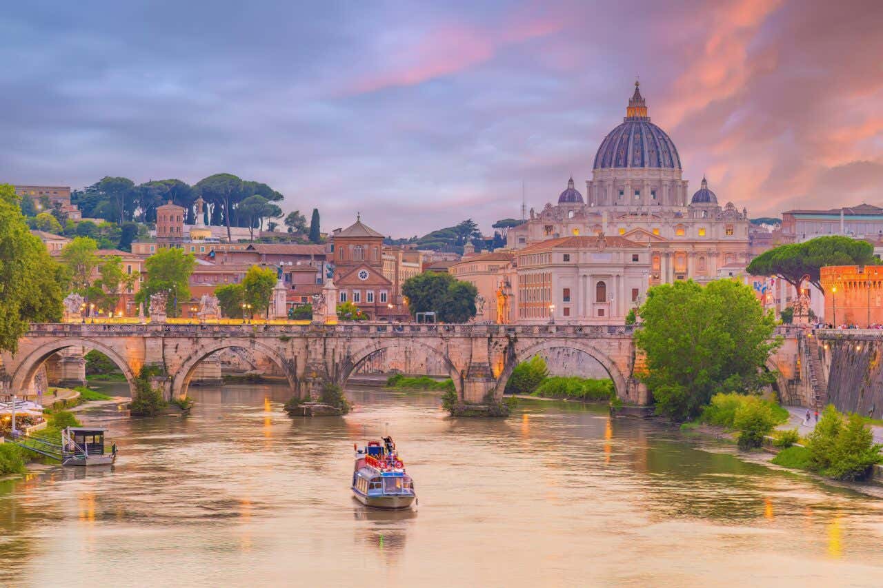Basilica di San Pietro, Ponte Sant'Angelo e altri monumenti al tramonto con barca che solca il Tevere