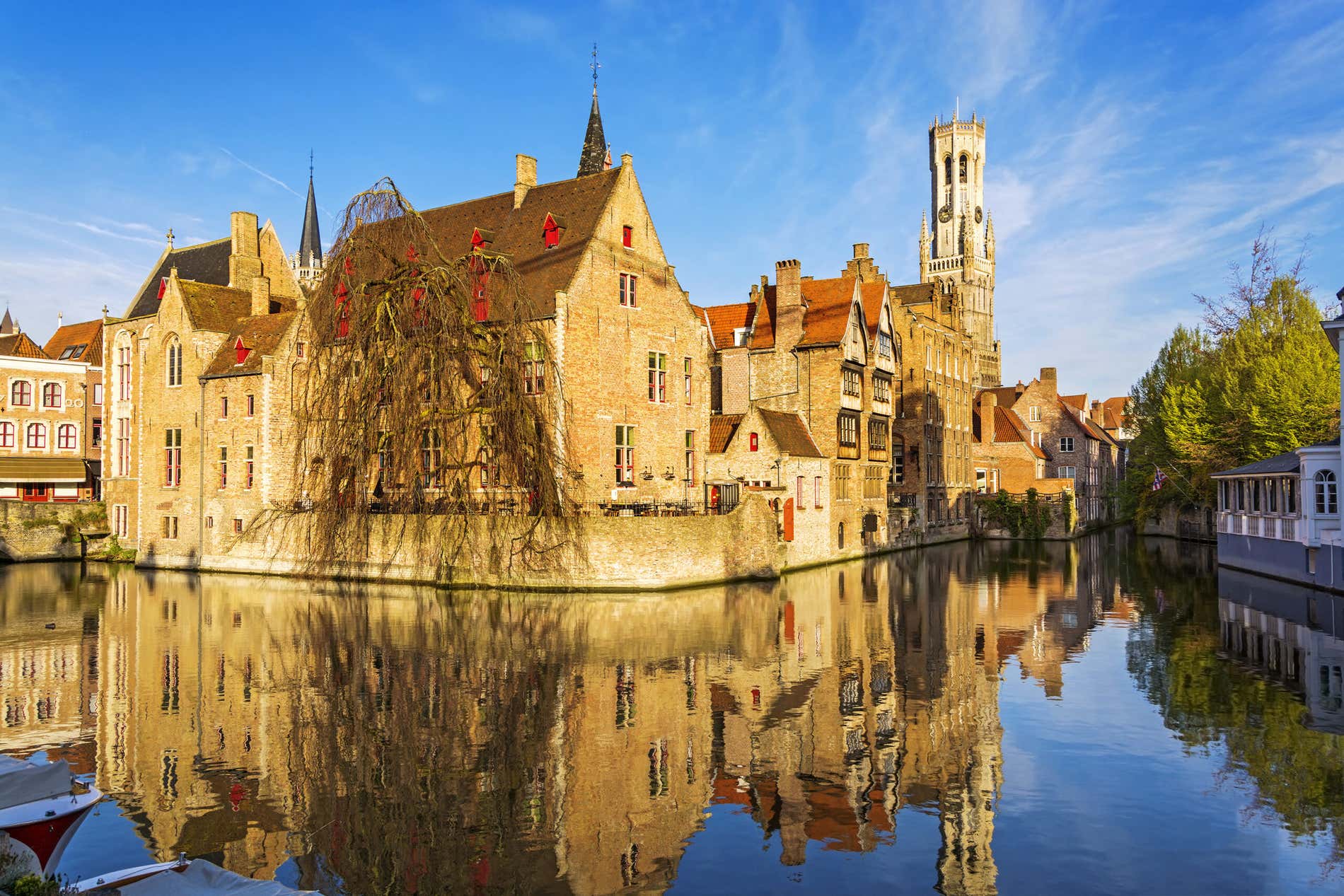 Un canale di Bruges al tramonto con case medievali sull'acqua