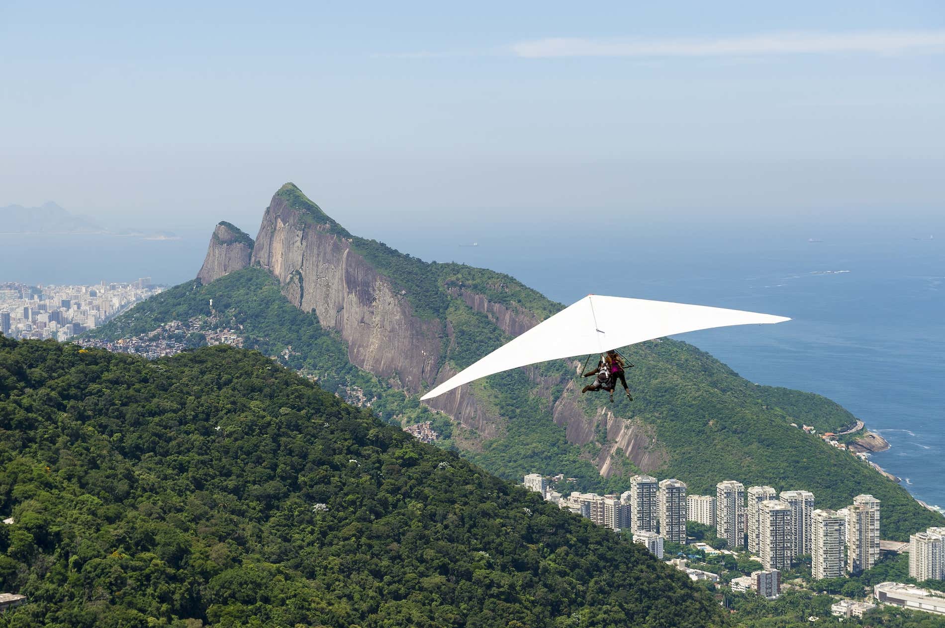 Um asa-delta voando da Pedra Bonita em direção à praia de São Conrado, no Rio de Janeiro