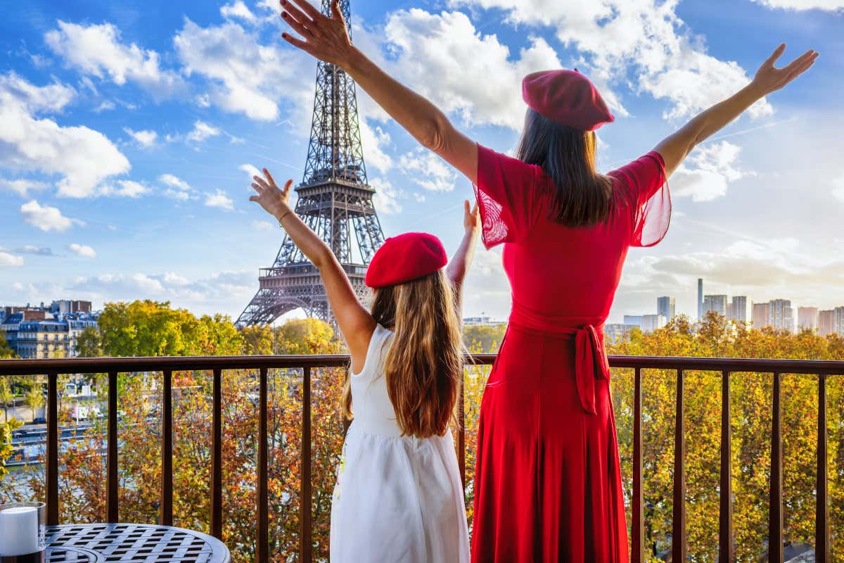 Una mujer y una niña de espaldas contemplando la Torre Eiffel en París
