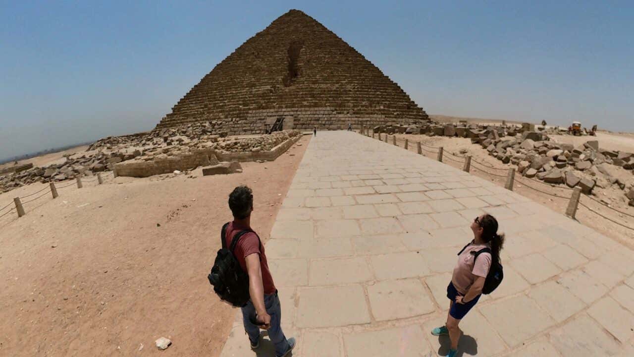 Un hombre y una mujer delante de la Gran Pirámide de Guiza, en Egipto.