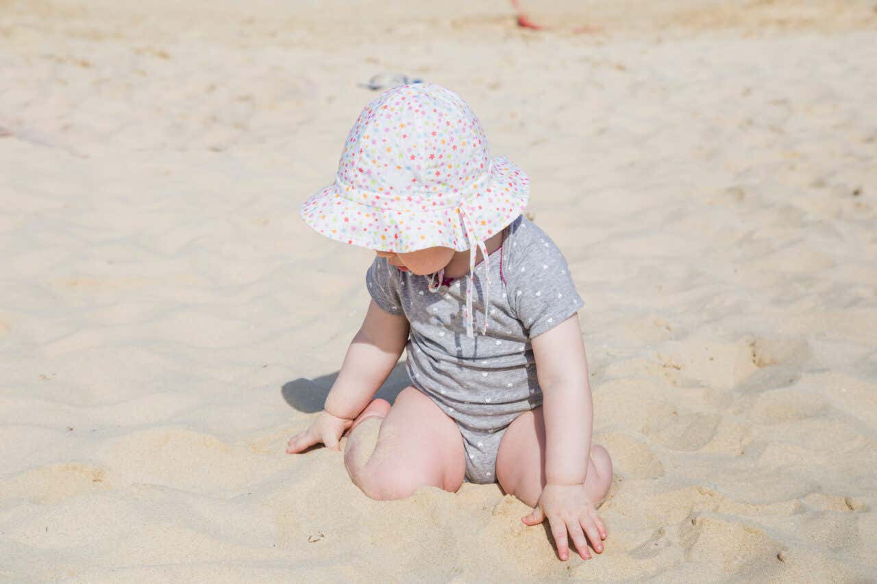 Uma menina brincando na areia da praia