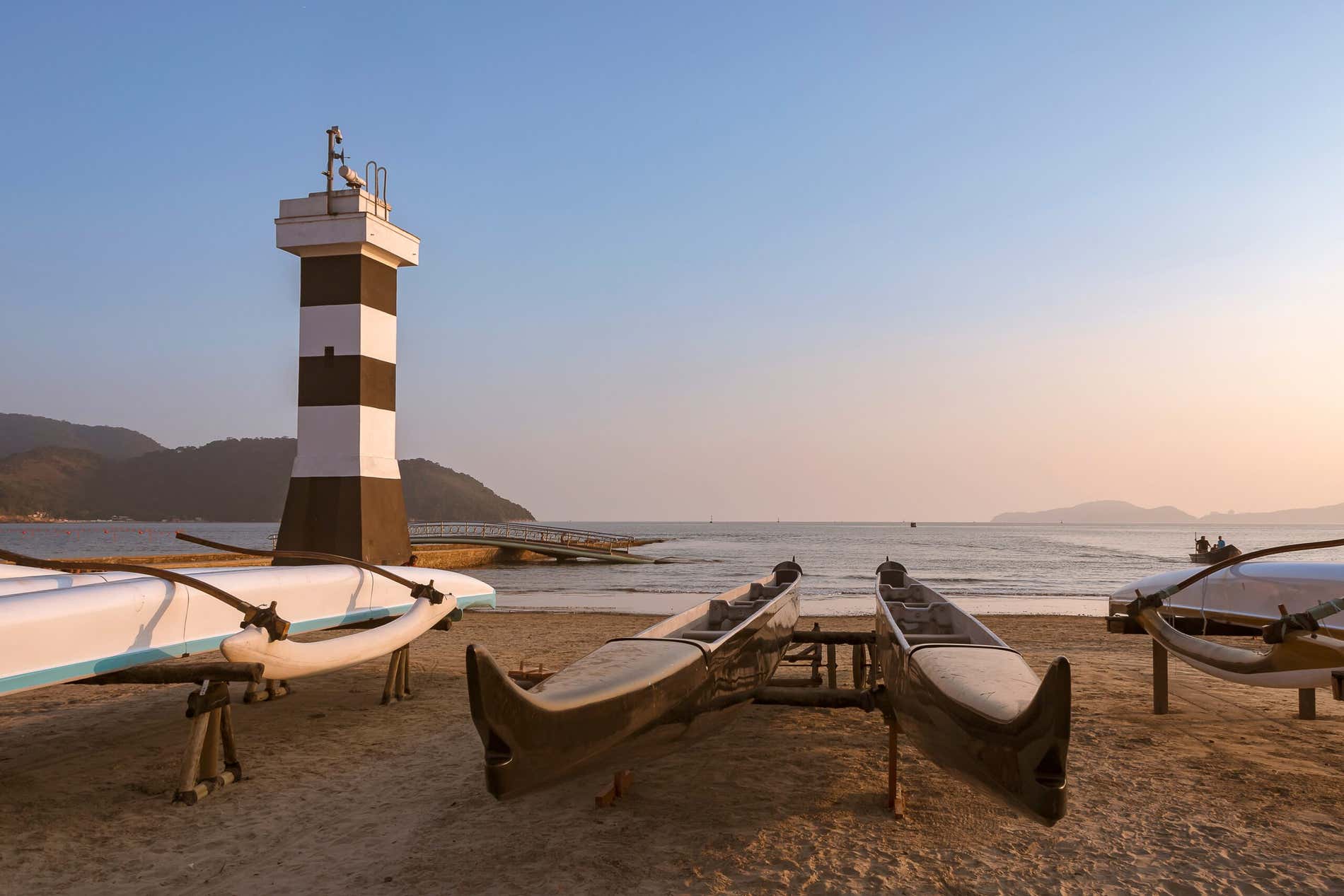 O Farol da Aparecida  ao lado de canoas havaiana, um passeio para você fazer em Santos