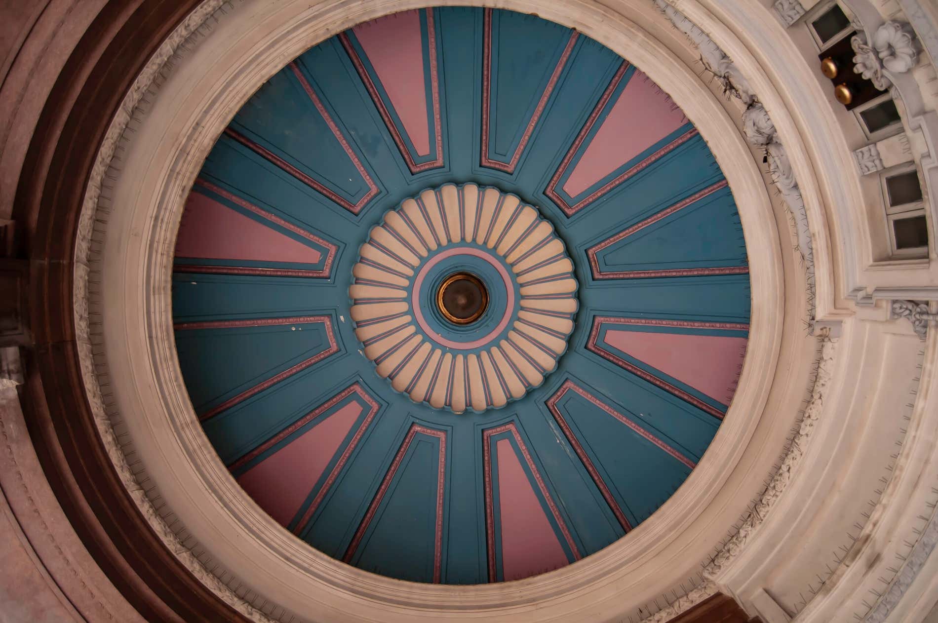 Um teto esculpido em tons azul e rosa