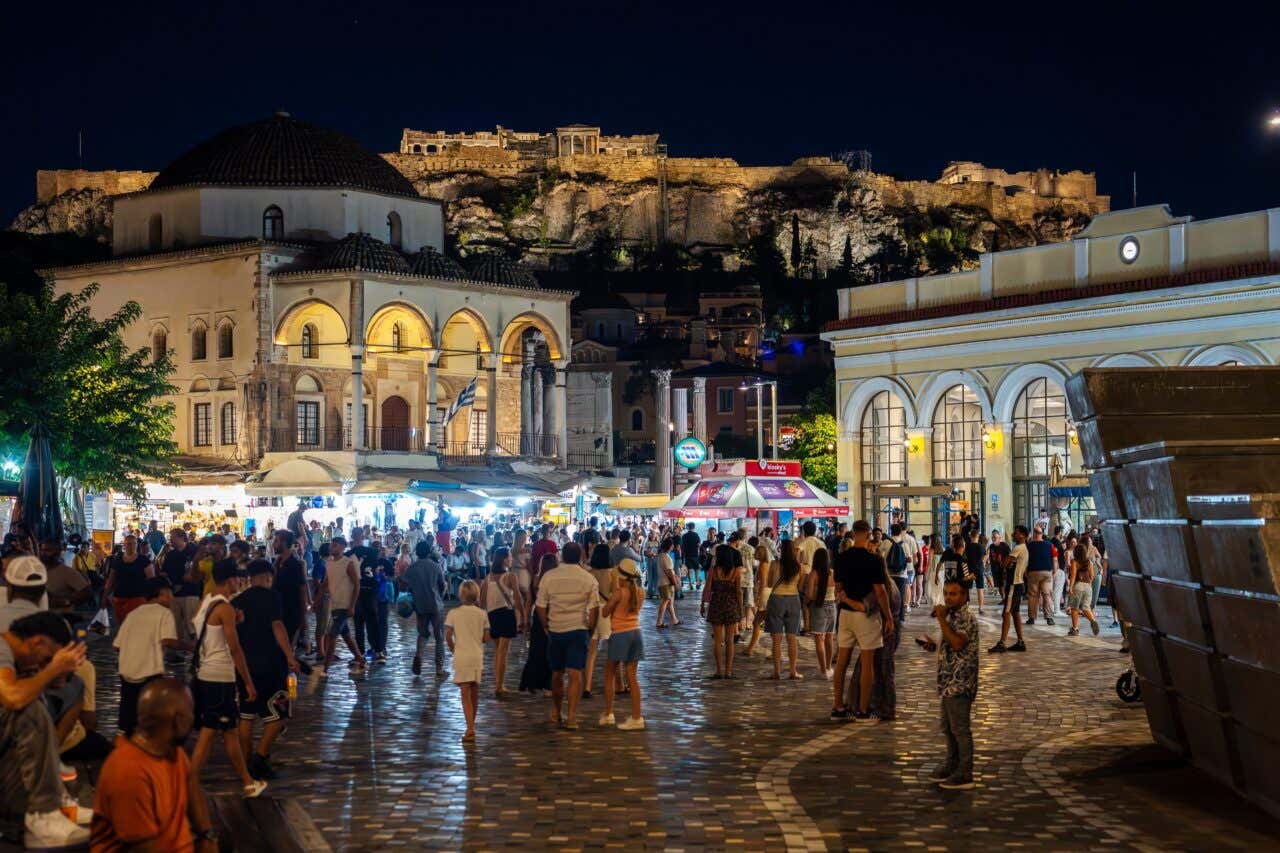 Monastiraki at night with the Acropolis lit up visibie in the background.