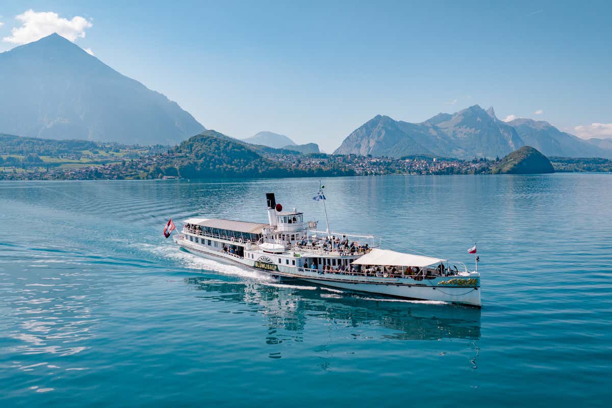 Barco de vapor con la bandera suiza navegando por un lago