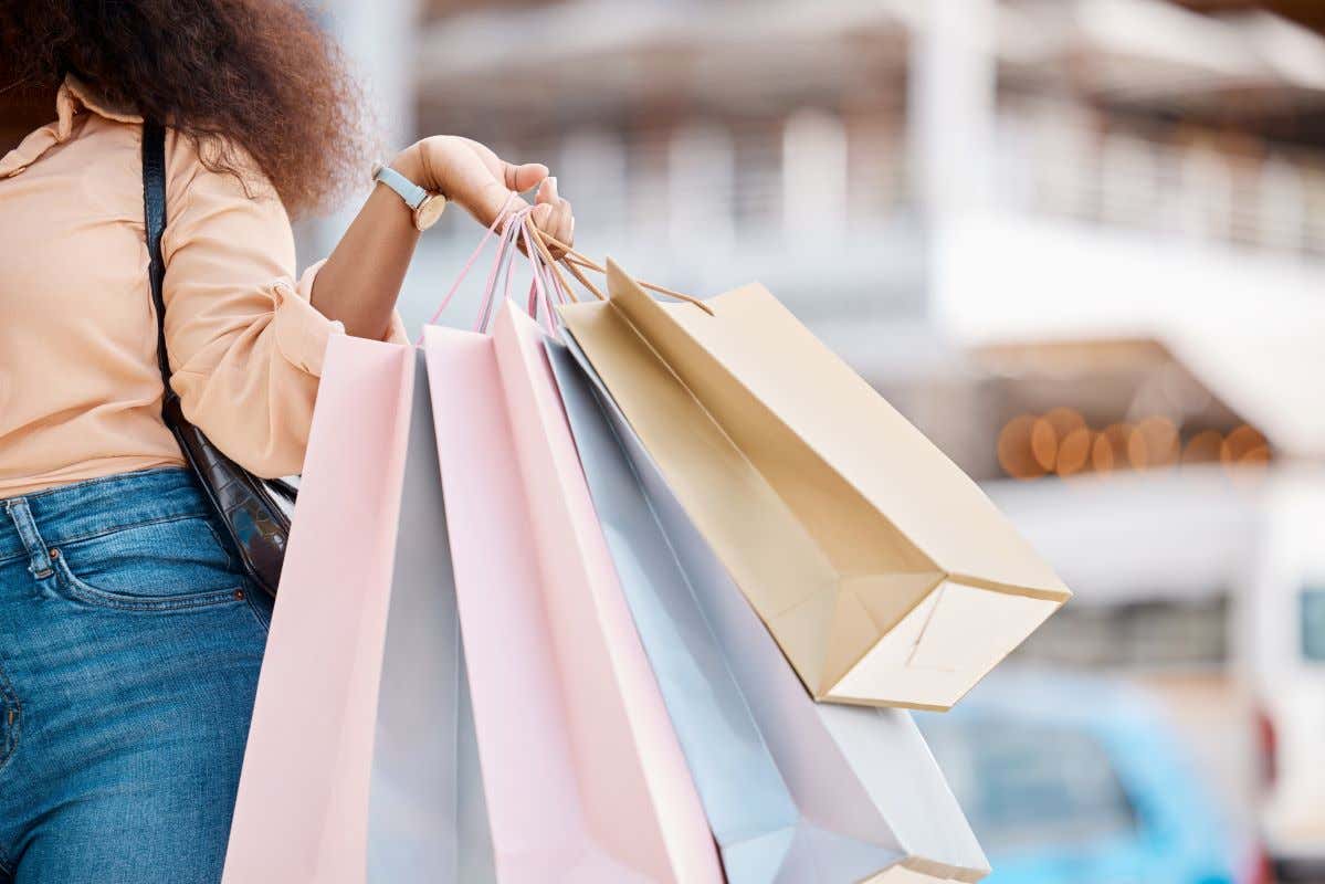 Detalle de una mano sujetando varias bolsas de compras en una calle de Nueva York