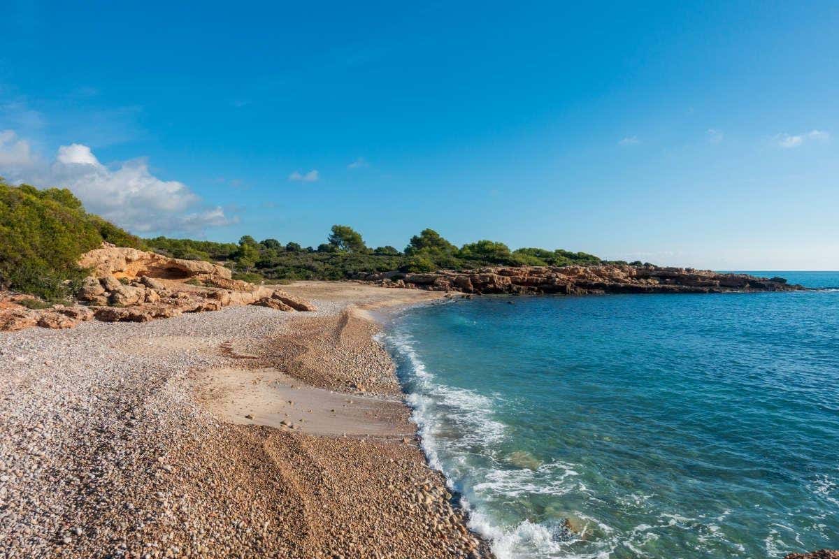Playa desierta de piedras con pequeños acantilados de bosques en la costa de Castellón