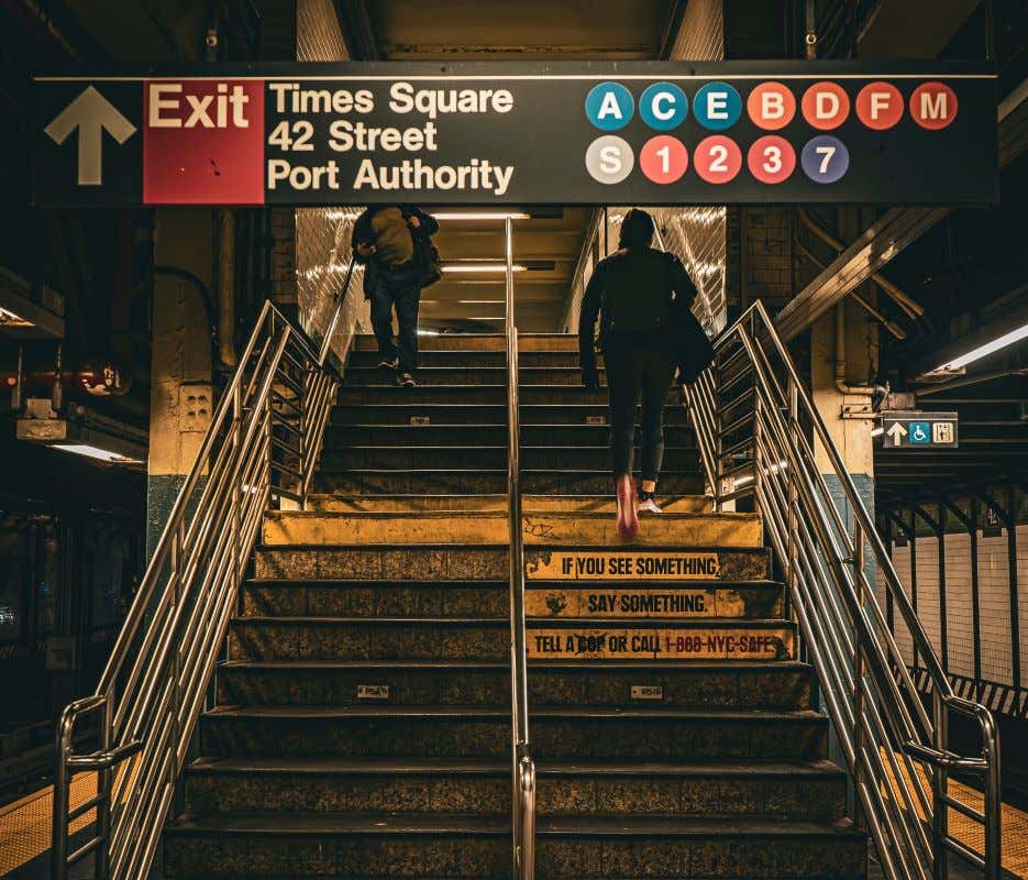 Una persona subiendo las escaleras en el interior del metro de Nueva York