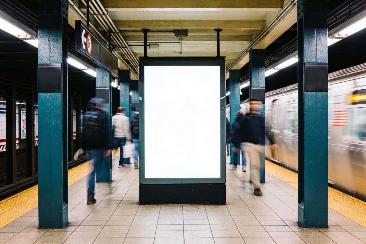 Varias personas caminando junto a las vías del metro de Nueva York