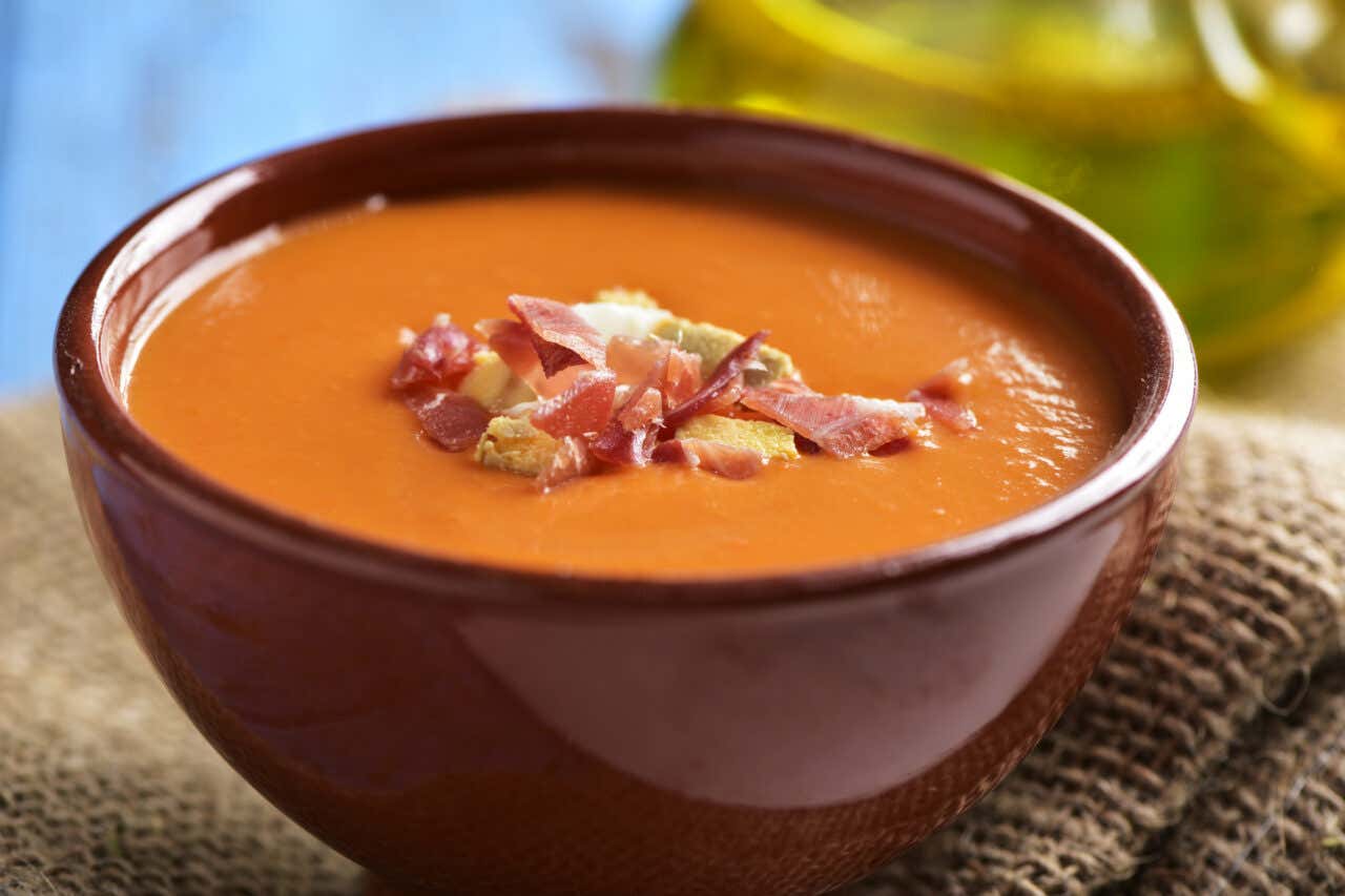 ciotola di salmorejo cordobese con crostini e prosciutto a scaglie sopra