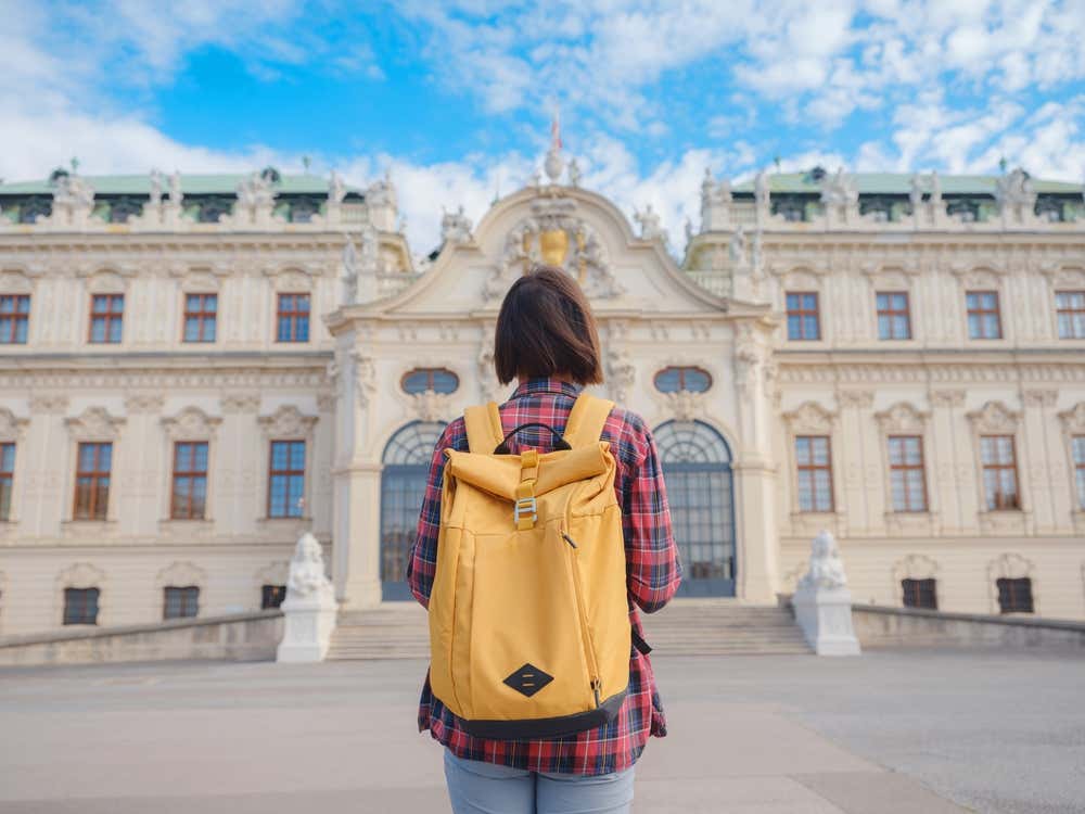 Una turista di spalle osserva la facciata del Palazzo di Hofburg, nel centro storico di Vienna