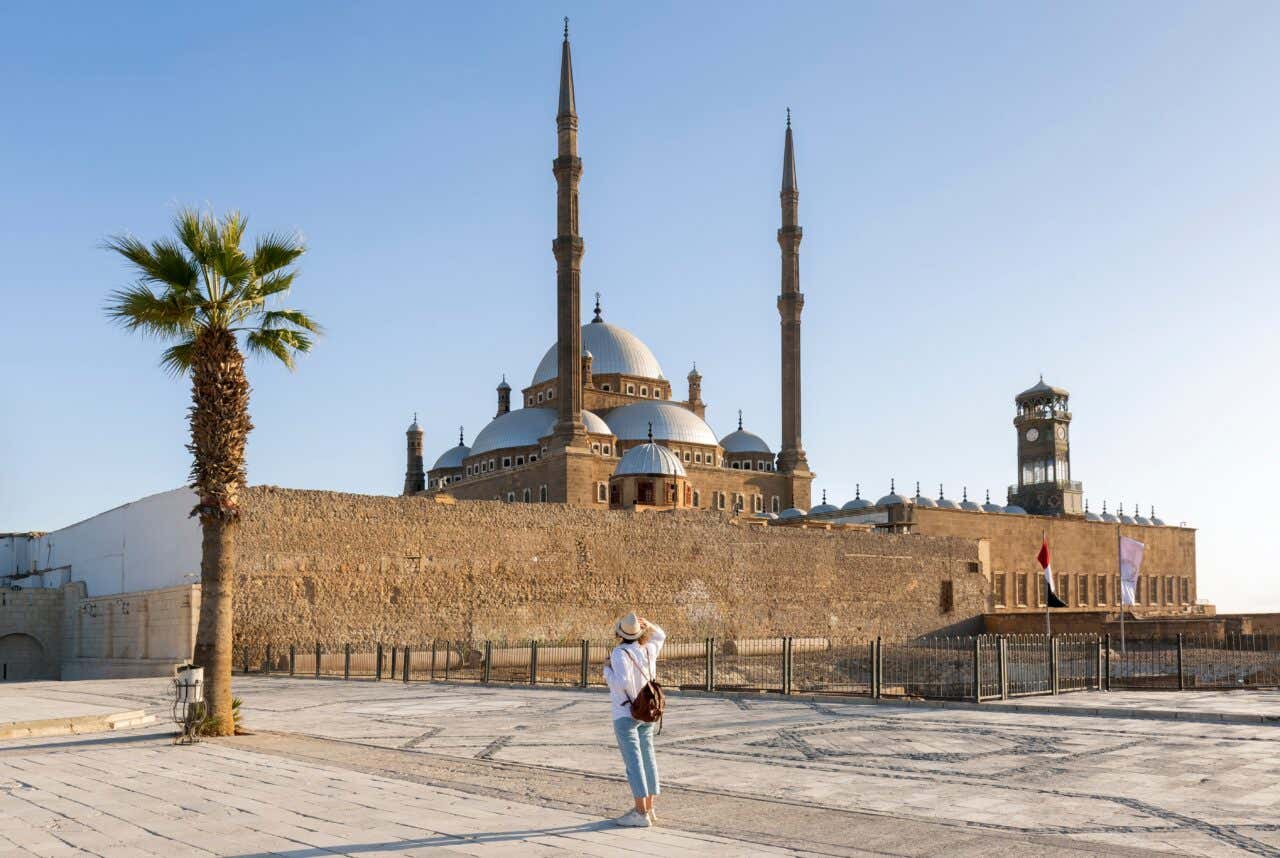Une personne de dos admire de l'extérieur la Mosquée de Mohammed Ali en Égypte