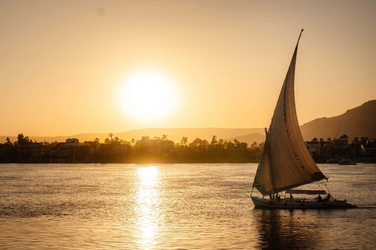 Une felouque naviguant sur le Nil au coucher du soleil, une expérience à vivre lors d'un voyage en Égypte