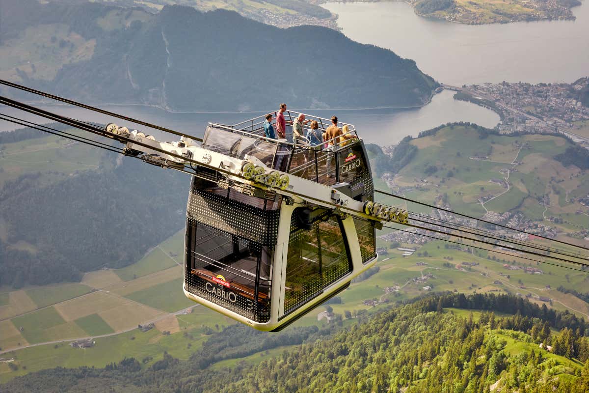Varias personas a bordo del teleférico descapotable de Stanserhorn, en Suiza