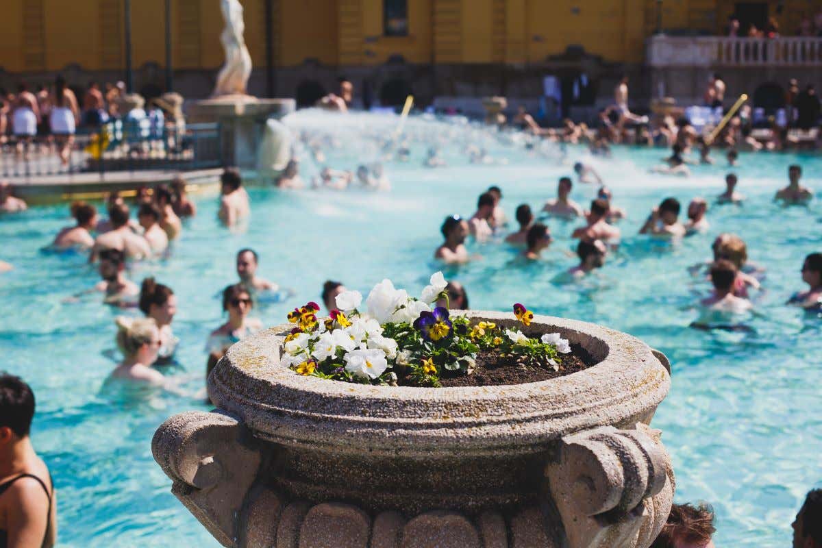 Varias personas bañándose en una piscina de agua termal en Budapest