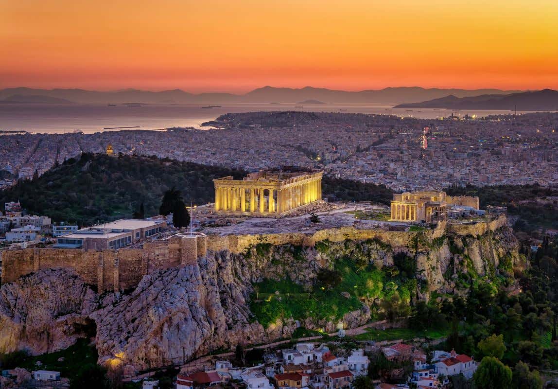 Vistas del atardecer en Atenas con el Partenón de la Acrópolis iluminado