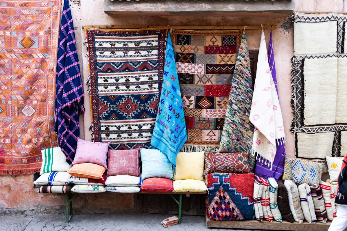 Un rincón con tejidos y alfombras en un mercado tradicional de Marrakech