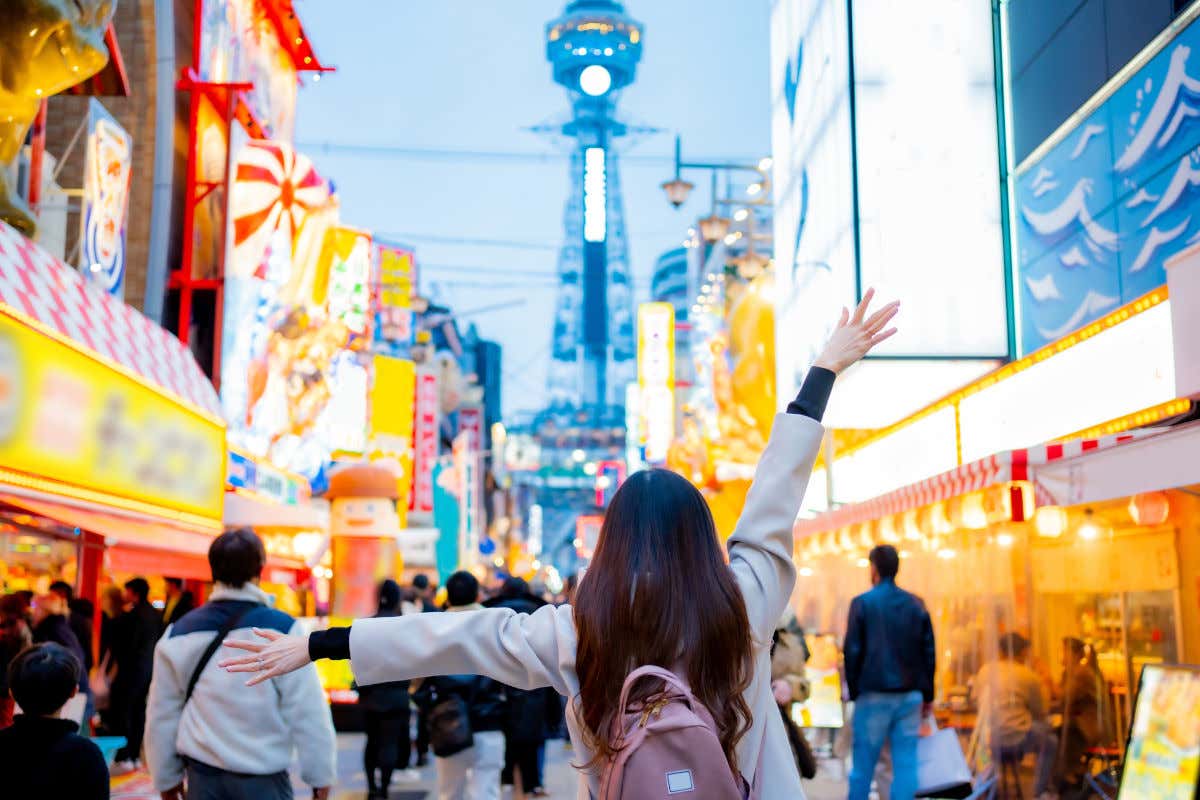 Una mujer disfrutando de la iluminación nocturna de una calle en Japón