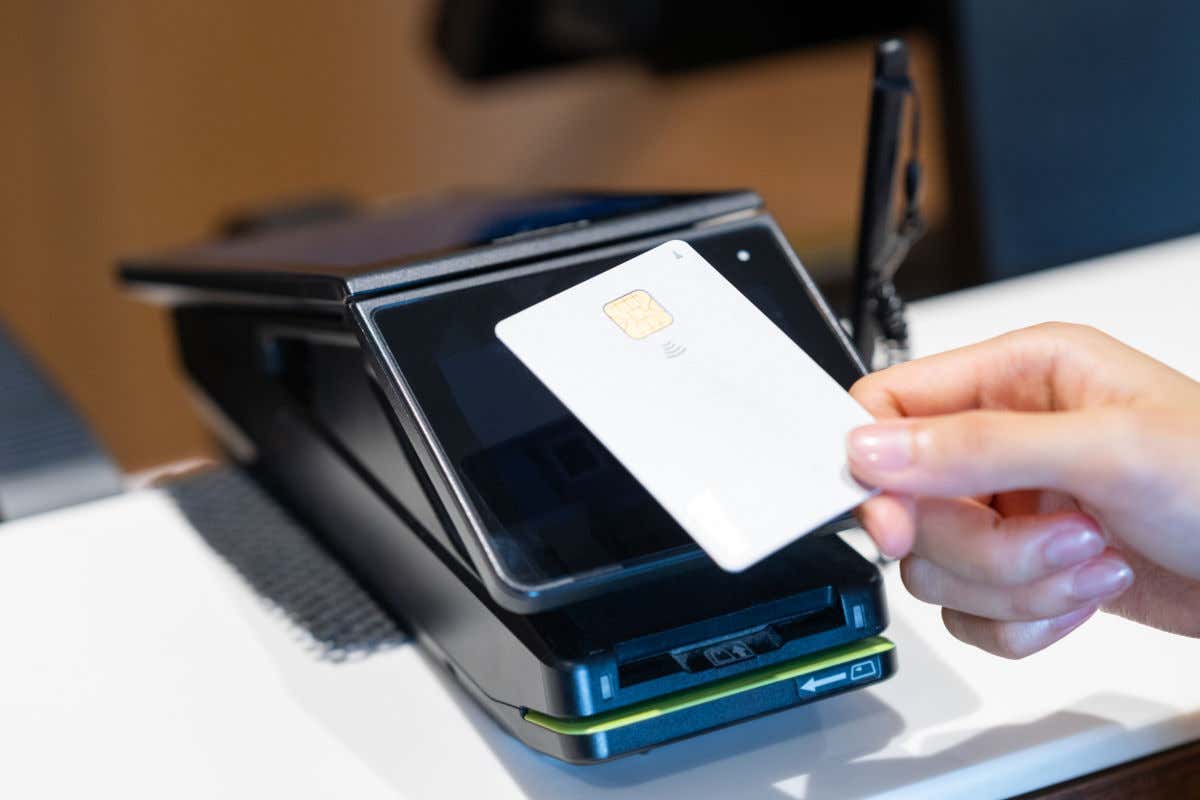 Una persona pagando con una tarjeta de crédito o débito un TPA con contactless