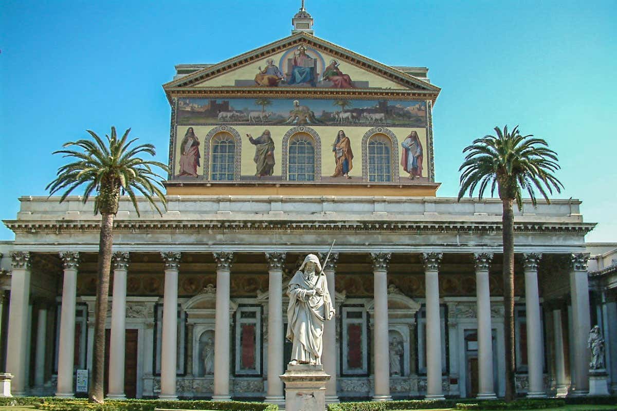 La fachada de la iglesia de San Pablo Intramuros con una estatua entre dos palmeras.