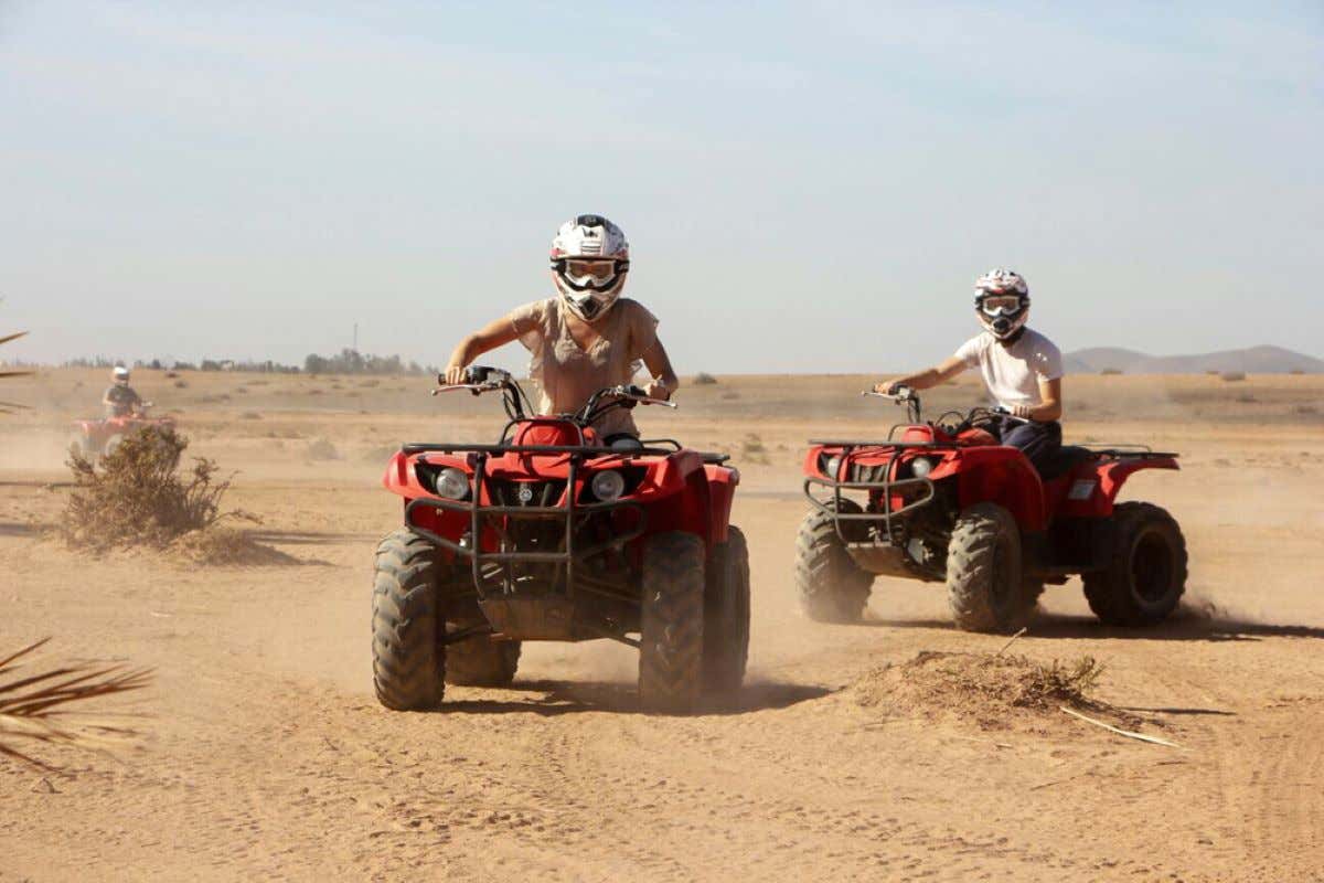 Two people on quads driving through the desert in Marrakech.