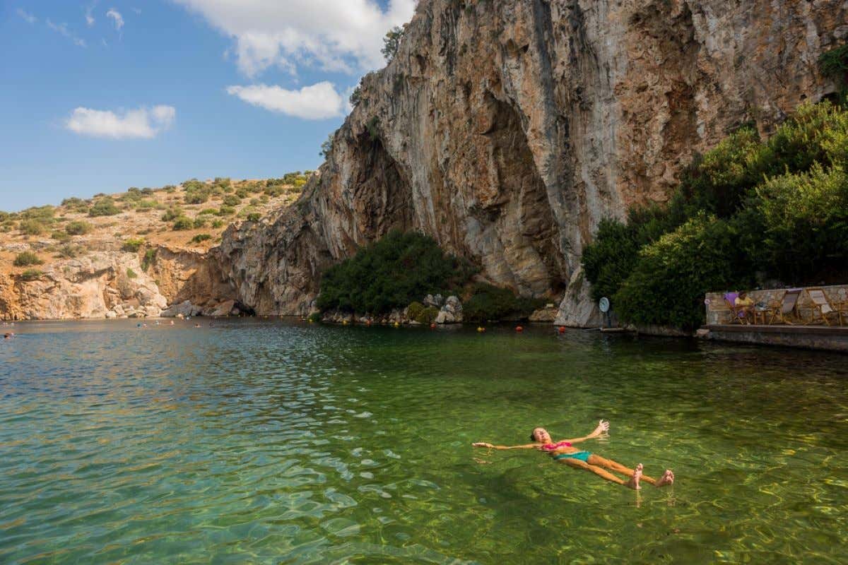 A woman floating in Lake Voulagmeni in Greece.
