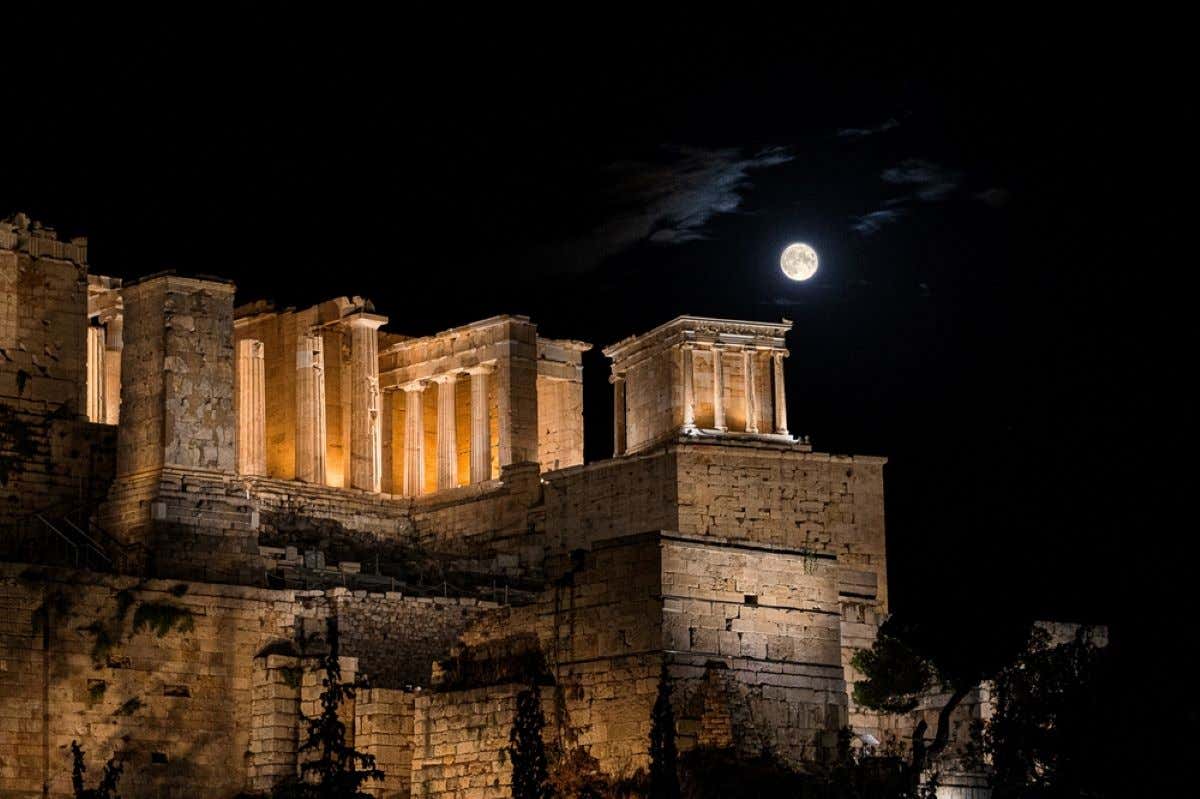 The Acropolis of Athens, a World Heritage Site, at night with the moon.