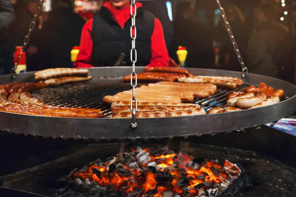 Salchichas alemanas en la parilla durante un mercadillo de Navidad