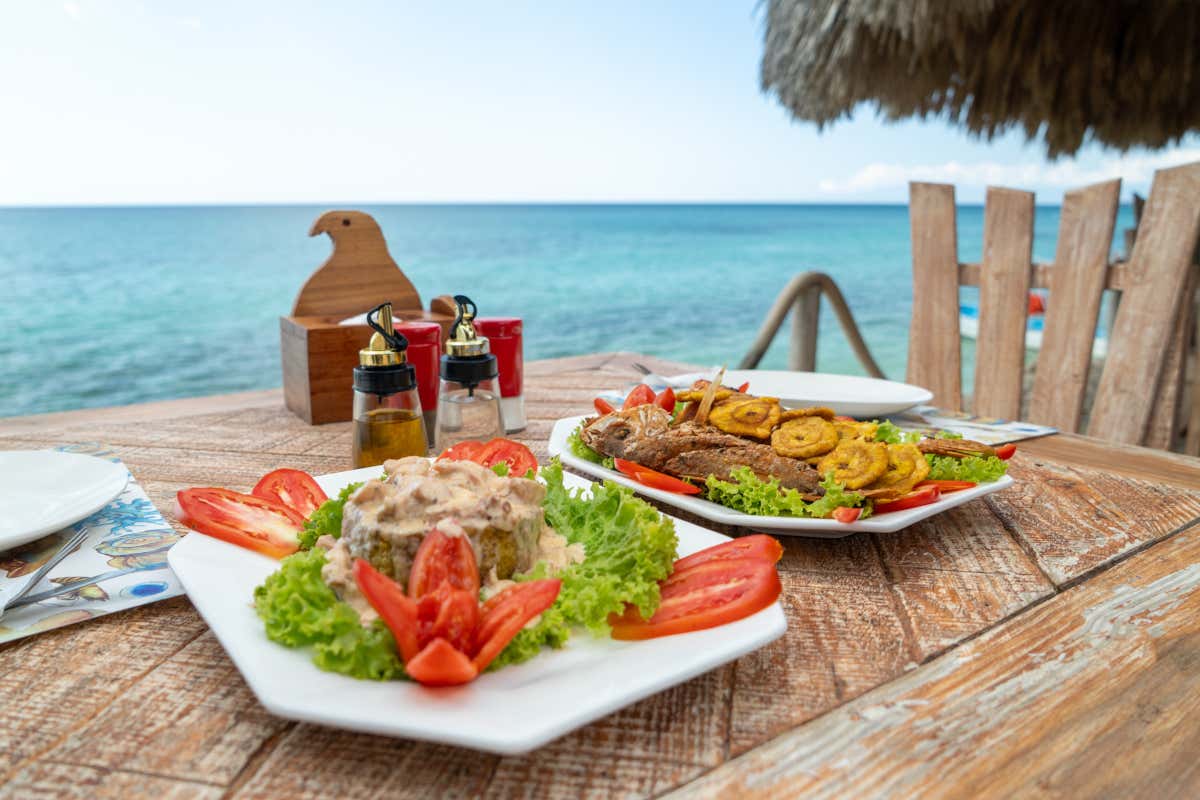 Platos de comida en una mesa junto al mar