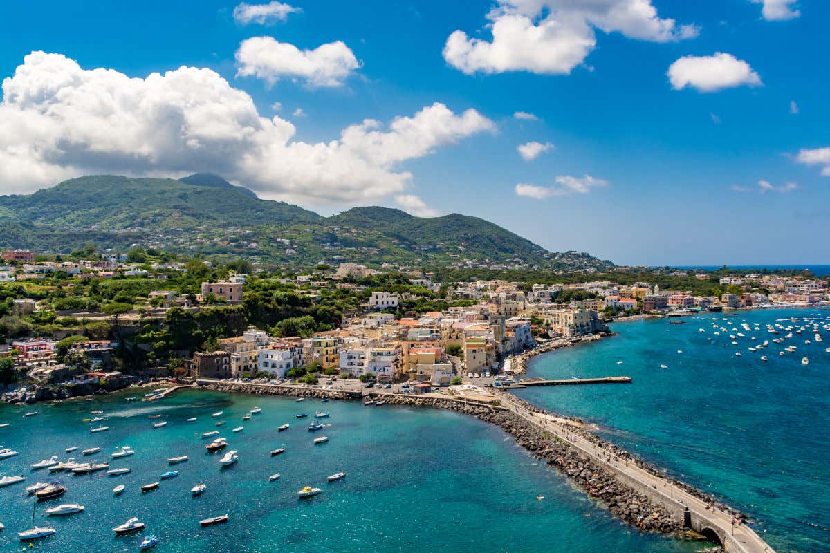 Montes y puerto de Ischia con varias casas y mar en calma