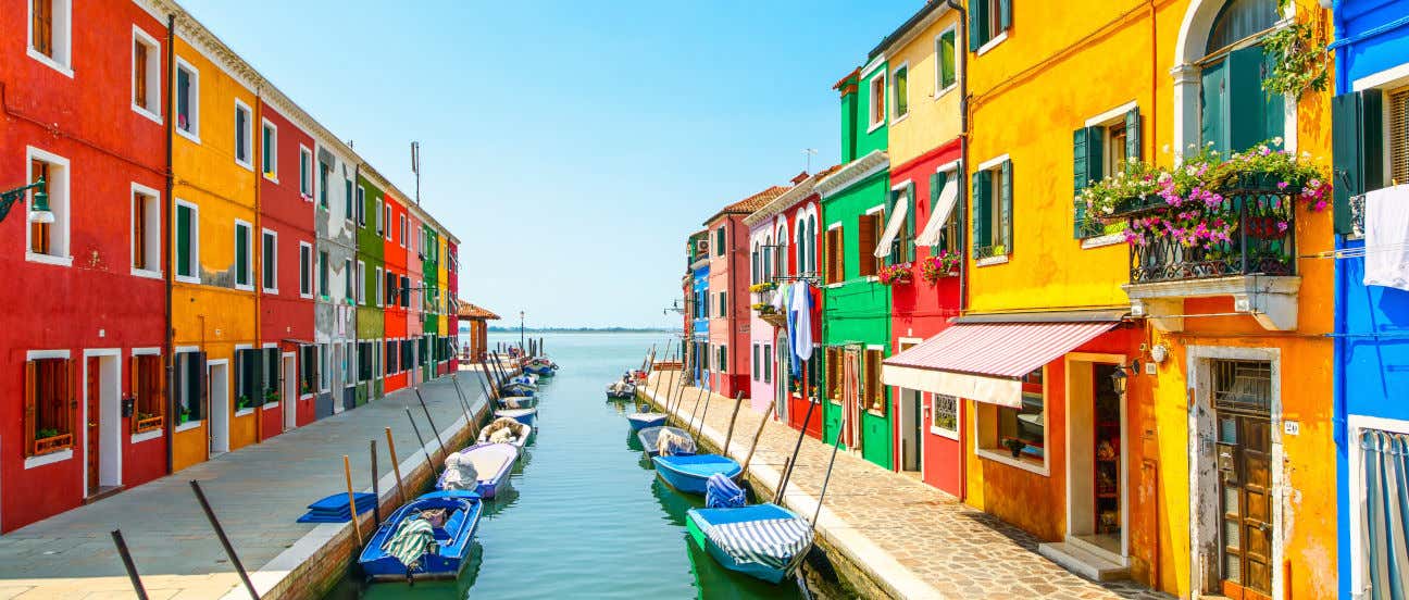 Casas de colores de la isla de Burano, con pequeños barcos junto a un canal
