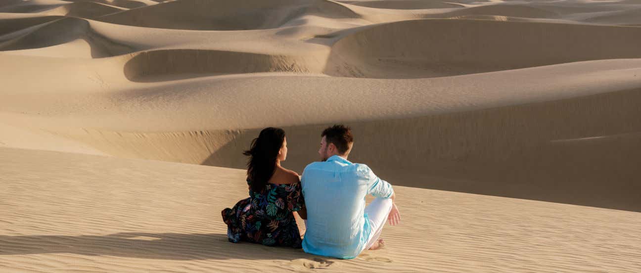 Una pareja sentada en las dunas de Maspalomas, en la isla de Gran Canaria