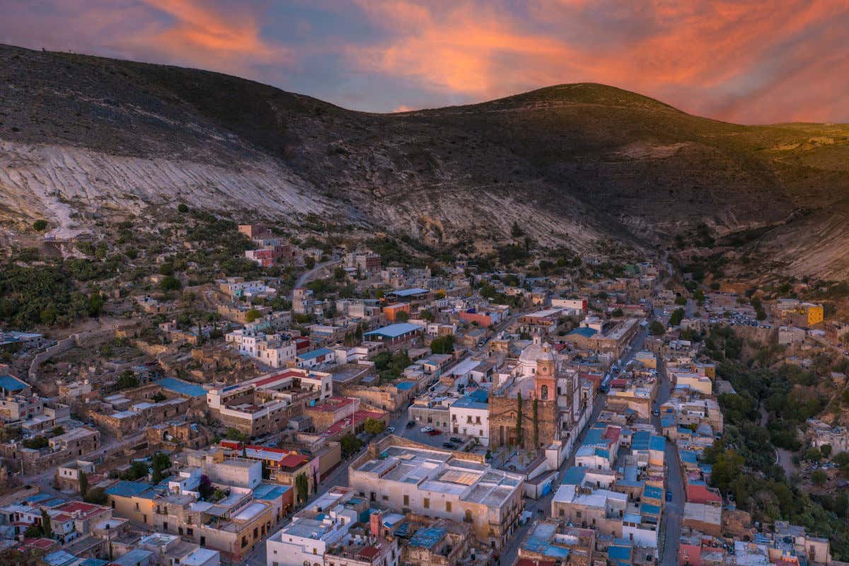 Vista aérea del Pueblo Mágico de Real de Catorce con sus casas y su iglesia rodeadas por un cerro