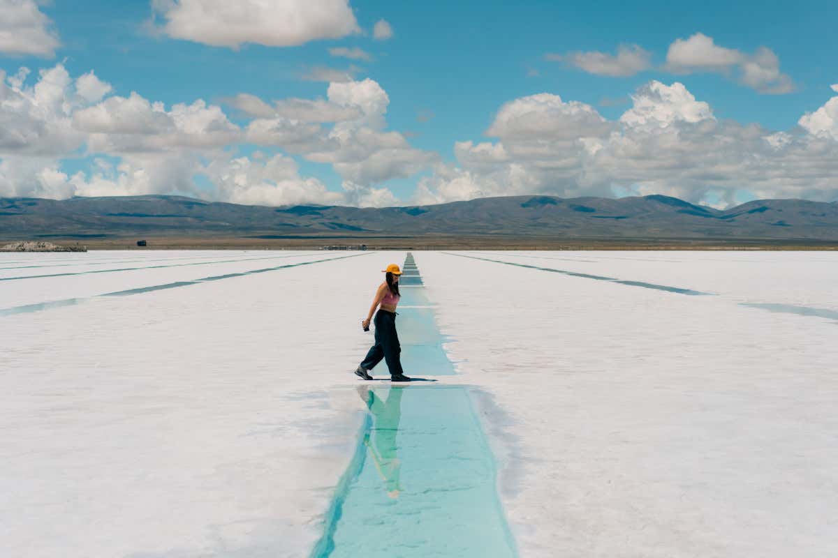 Una mujer paseando por el paisaje blanco de una salinas en Salta