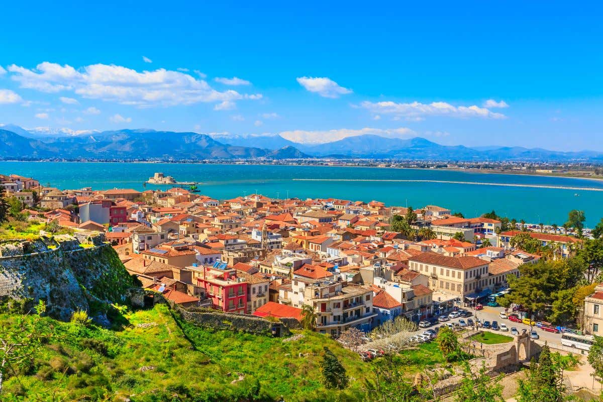 Aerial view of the city of Nafplio in Greece with the sea and the Bourtzi Castle in the distance.
