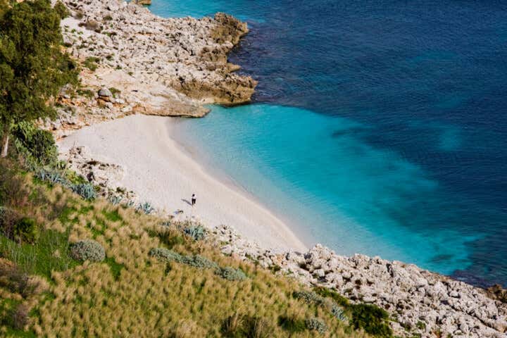 Foto dall'alto di Cala Marinella, una piccola spiaggia di sabbia bianca all'interno della Riserva dello Zingaro, in Sicilia